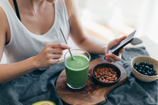 Woman drinking green smoothie with avocado and almonds.