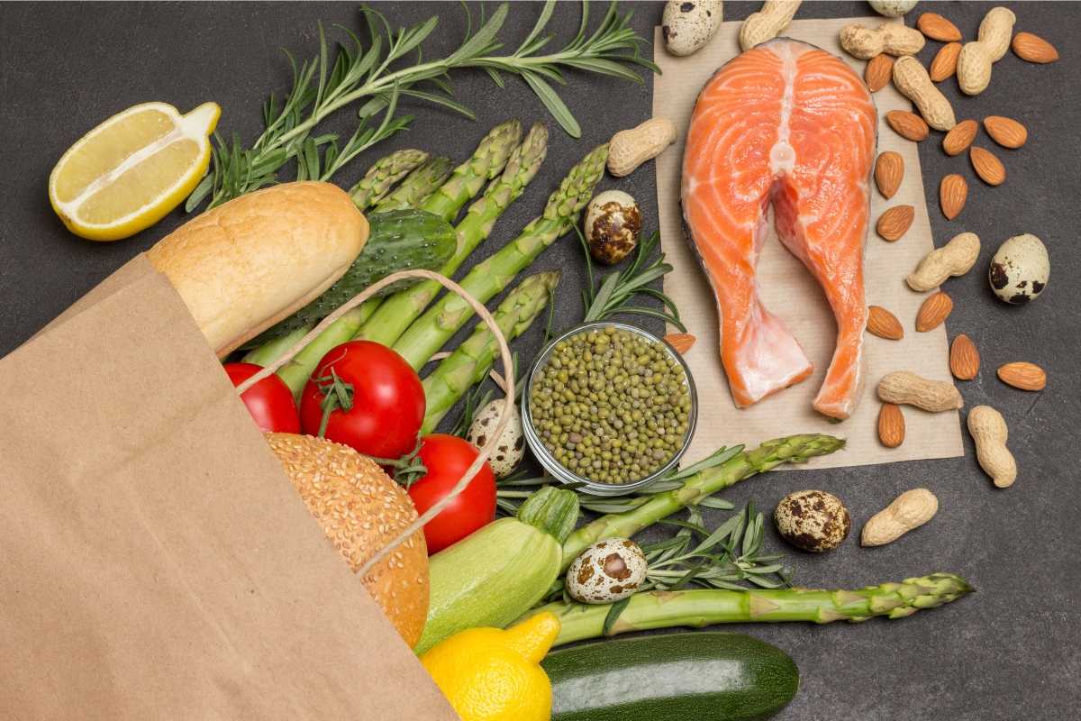 Fresh and healthy assortment of fruits, vegetables, salmon, and nuts.