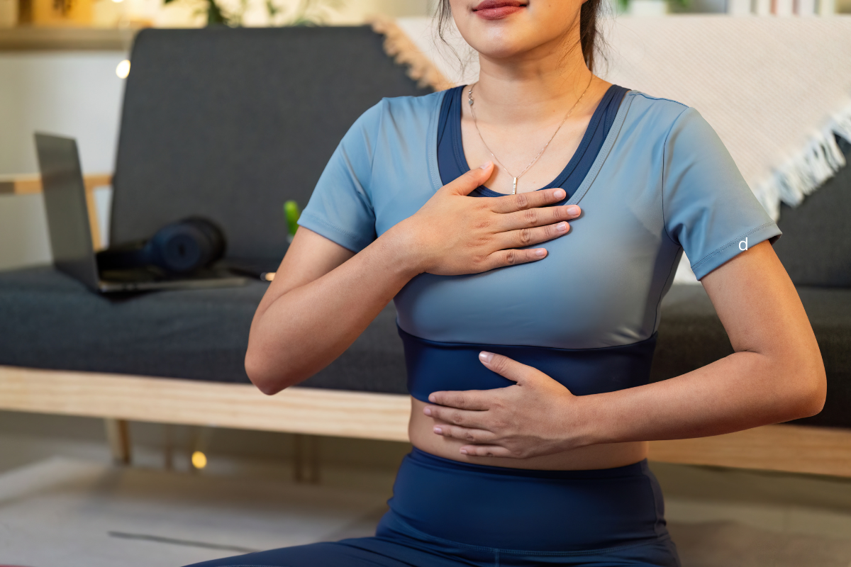 Person practicing deep diaphragmatic breathing with one hand on the chest and one on the abdomen.