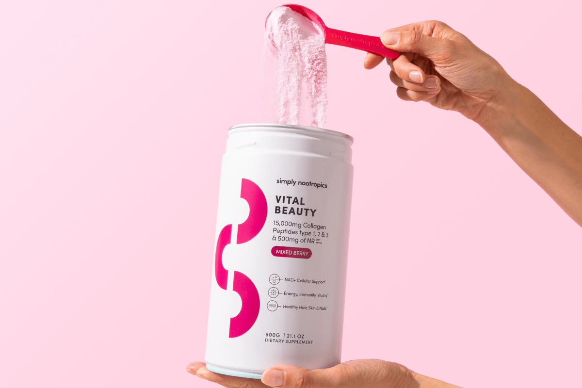 Hand scooping Vital Beauty collagen powder from a Simply Nootropics container.